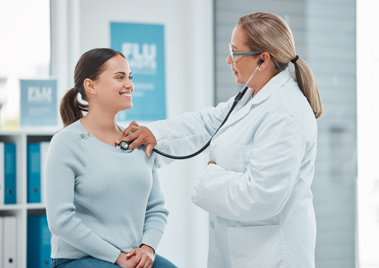 Doctor using stethoscope on woman