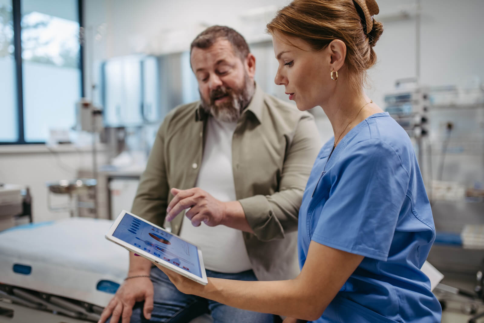 Medical provider showing man diagnostics on a tablet screen